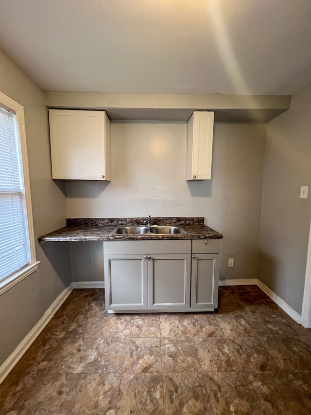 19190 Hoover St, Detroit, MI 48205 - kitchen with a sink, dark countertops, white cabinetry, baseboards, and plenty of natural light