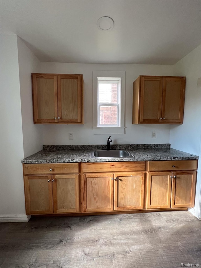 16895 Cruse St, Detroit, MI 48235 - kitchen with a sink, dark countertops, brown cabinetry, and light wood-type flooring