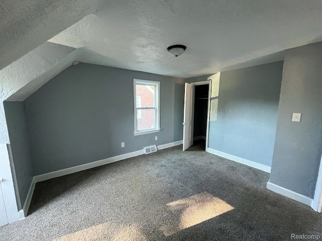 16895 Cruse St, Detroit, MI 48235 - unfurnished bedroom featuring a textured ceiling, vaulted ceiling, carpet flooring, and baseboards