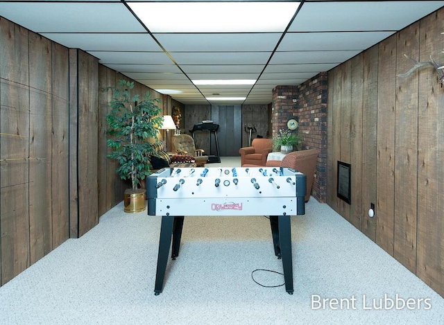 game room featuring wood walls, a drop ceiling, and carpet