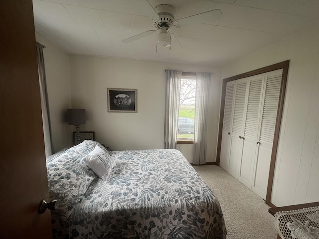 bedroom featuring a ceiling fan, light carpet, and a closet