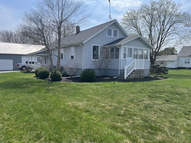 view of front facade with a sunroom, a front lawn, and a chimney