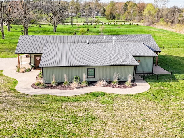 view of side of home featuring a yard, fence, and metal roof