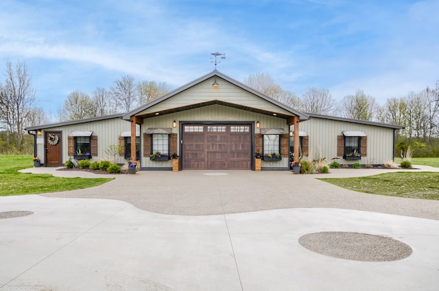 view of front of home with board and batten siding, curved driveway, and a garage
