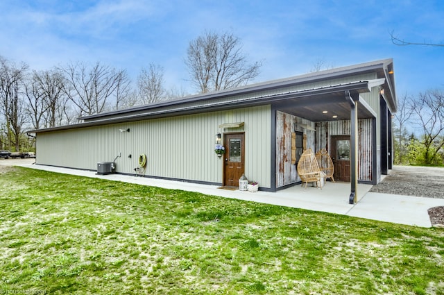 back of house with a lawn and central AC