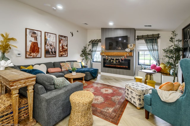 living room with recessed lighting, visible vents, and a large fireplace