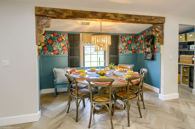 dining room featuring baseboards, an inviting chandelier, visible vents, and a wainscoted wall