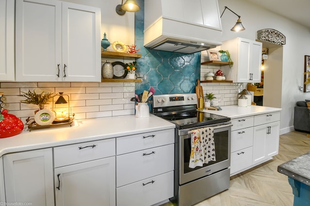 kitchen with open shelves, stainless steel range with electric cooktop, white cabinets, and custom exhaust hood