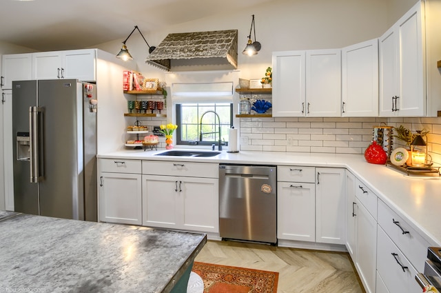 kitchen with stainless steel appliances, a sink, white cabinetry, open shelves, and light countertops