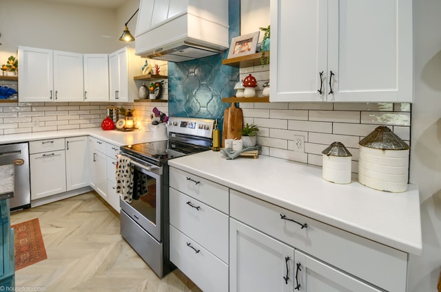 kitchen featuring premium range hood, stainless steel appliances, open shelves, and white cabinetry