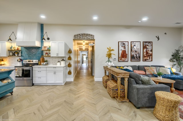 kitchen featuring open shelves, custom exhaust hood, white cabinetry, open floor plan, and electric stove
