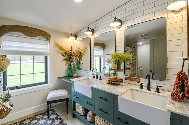full bath featuring double vanity, decorative backsplash, and a sink