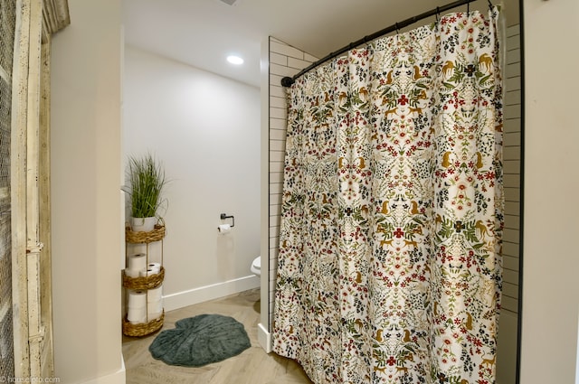bathroom with toilet, curtained shower, baseboards, and recessed lighting