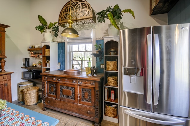bar featuring black microwave, stainless steel fridge, wood finished floors, and a sink