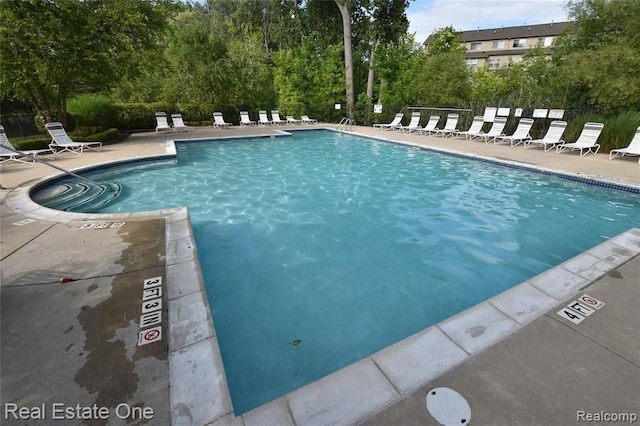community pool featuring fence and a patio area
