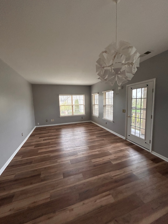 unfurnished dining area with baseboards and dark wood-type flooring