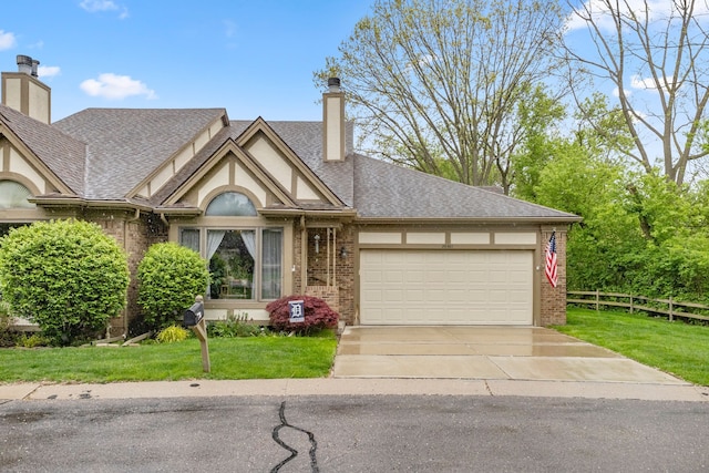 26901 Ann Arbor Trl, Dearborn Heights, MI 48127 - tudor house with brick siding, a chimney, an attached garage, concrete driveway, and stucco siding