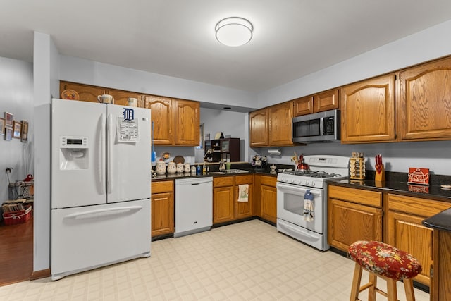 26901 Ann Arbor Trl, Dearborn Heights, MI 48127 - kitchen featuring white appliances, brown cabinetry, dark countertops, and light floors