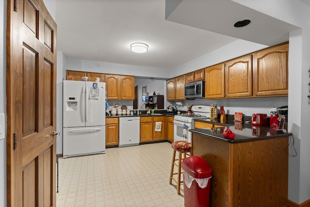 26901 Ann Arbor Trl, Dearborn Heights, MI 48127 - kitchen with white appliances, brown cabinetry, dark countertops, and light floors