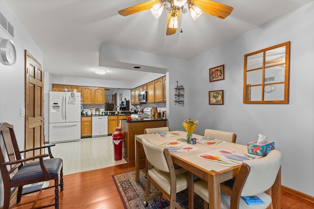 26901 Ann Arbor Trl, Dearborn Heights, MI 48127 - dining room featuring light wood-style flooring, ceiling fan, and baseboards