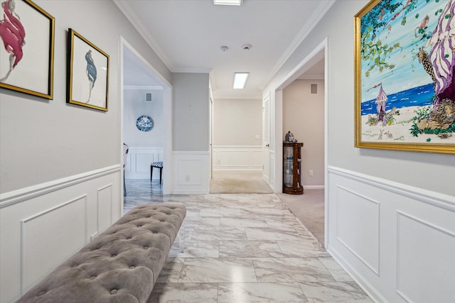 hall with ornamental molding, a wainscoted wall, marble finish floor, and a decorative wall