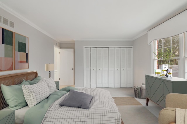 bedroom with visible vents, carpet, crown molding, and a closet