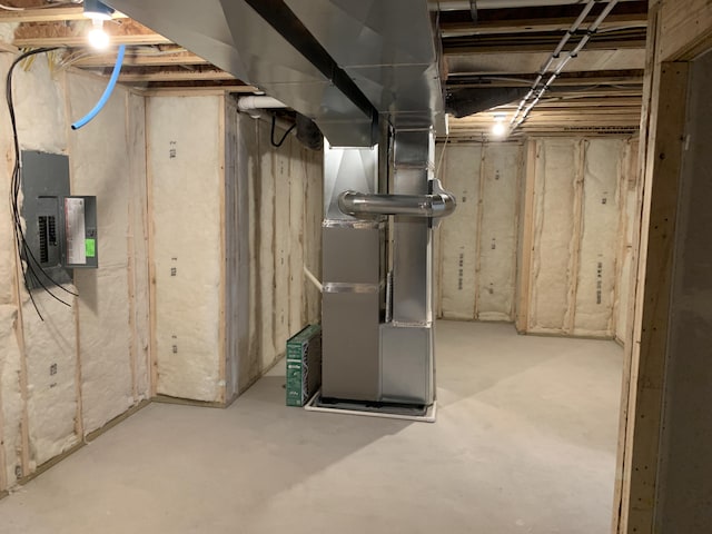 unfinished below grade area featuring heating unit and electric panel