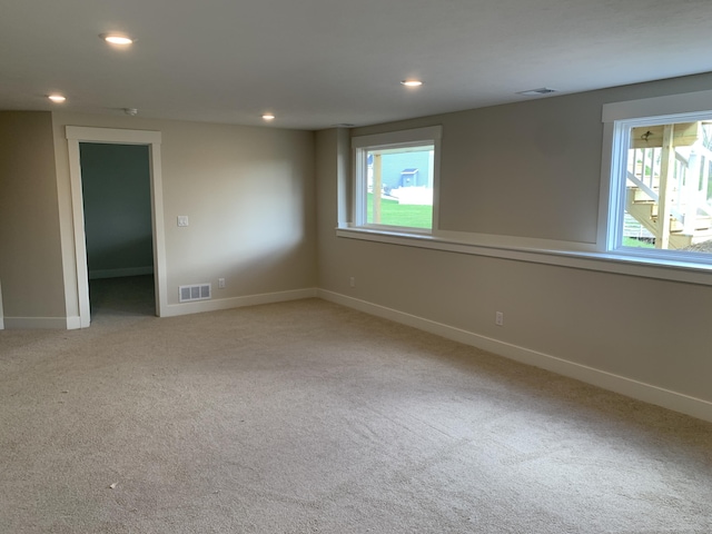spare room with carpet flooring, visible vents, and a wealth of natural light