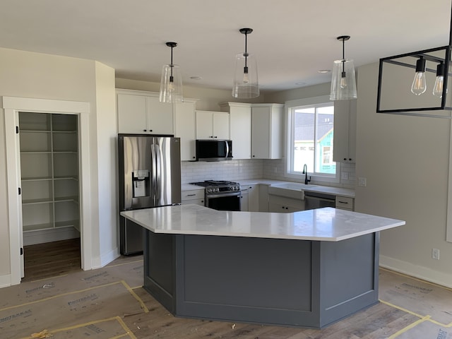 kitchen with light wood finished floors, light countertops, stainless steel appliances, white cabinetry, and tasteful backsplash