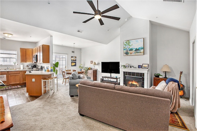 7200 Addington Dr, Commerce Twp, MI 48390 - carpeted living room featuring vaulted ceiling, a fireplace, a ceiling fan, and plenty of natural light