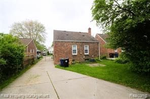 view of property exterior featuring a lawn and driveway