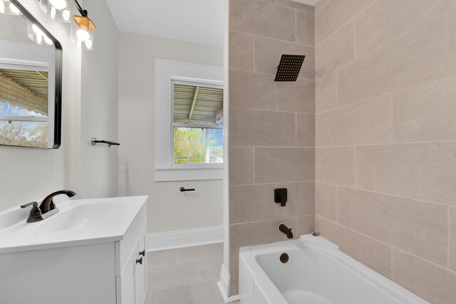 bathroom featuring vanity, baseboards, tub / shower combination, and tile patterned flooring