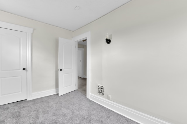 unfurnished bedroom with carpet flooring and baseboards