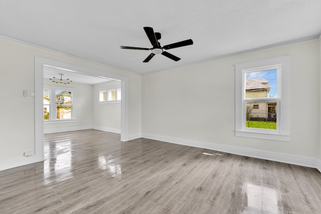 unfurnished room featuring baseboards, wood finished floors, crown molding, a chandelier, and a ceiling fan