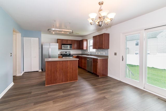 kitchen featuring visible vents, a kitchen island, a chandelier, dark wood finished floors, and appliances with stainless steel finishes