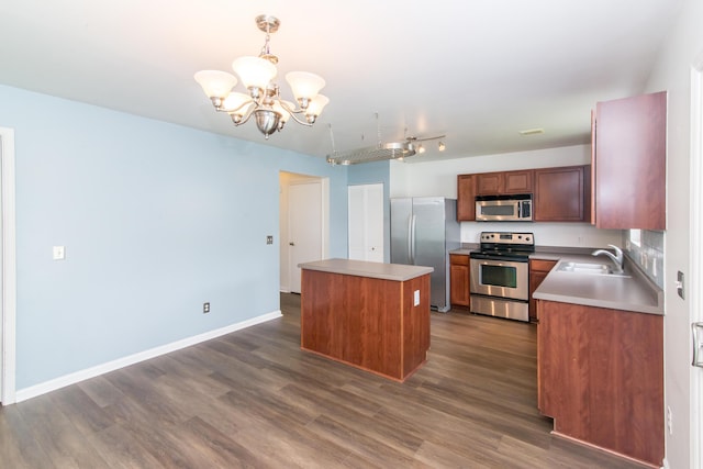 kitchen with an inviting chandelier, dark wood finished floors, a kitchen island, and stainless steel appliances