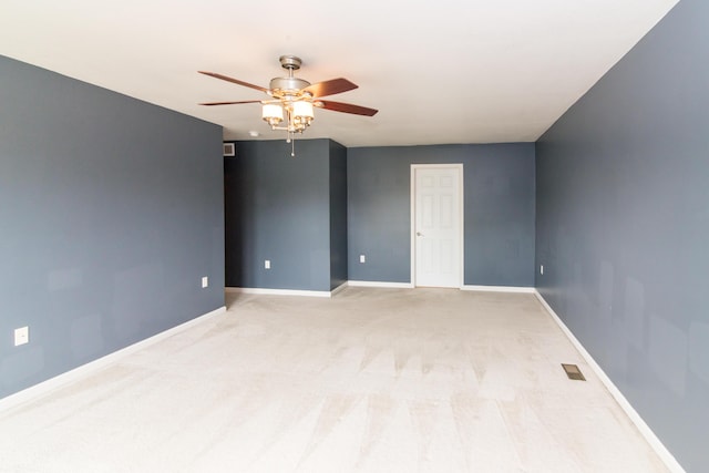 unfurnished room with a ceiling fan, baseboards, visible vents, and light carpet