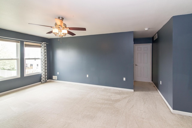 unfurnished room with ceiling fan, light colored carpet, and baseboards