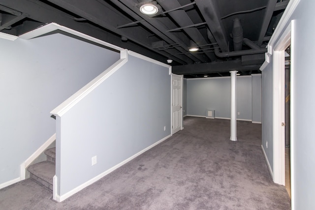 finished below grade area featuring baseboards, carpet, and stairway