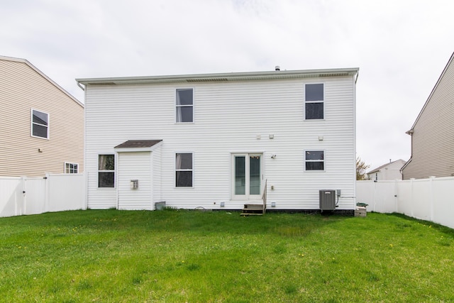 back of property with a lawn, a fenced backyard, and central air condition unit