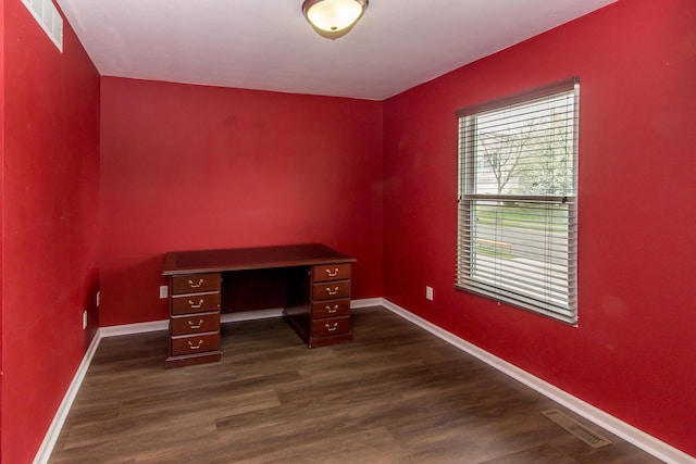 unfurnished office with visible vents, baseboards, and dark wood-type flooring