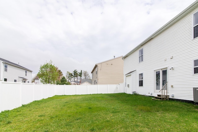 view of yard featuring central AC unit, fence, and entry steps