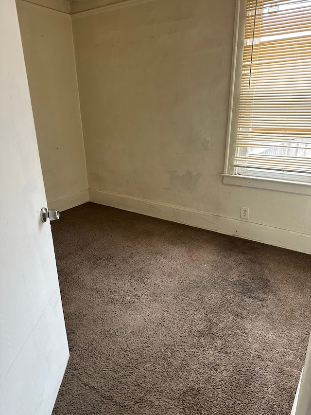 unfurnished room with dark colored carpet
