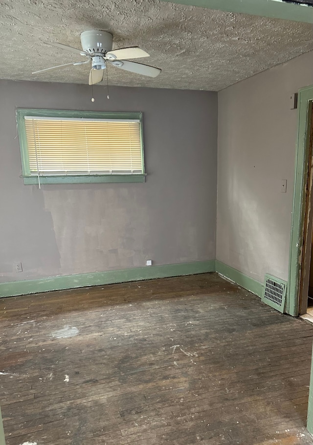 spare room with a textured ceiling, visible vents, a ceiling fan, and hardwood / wood-style floors