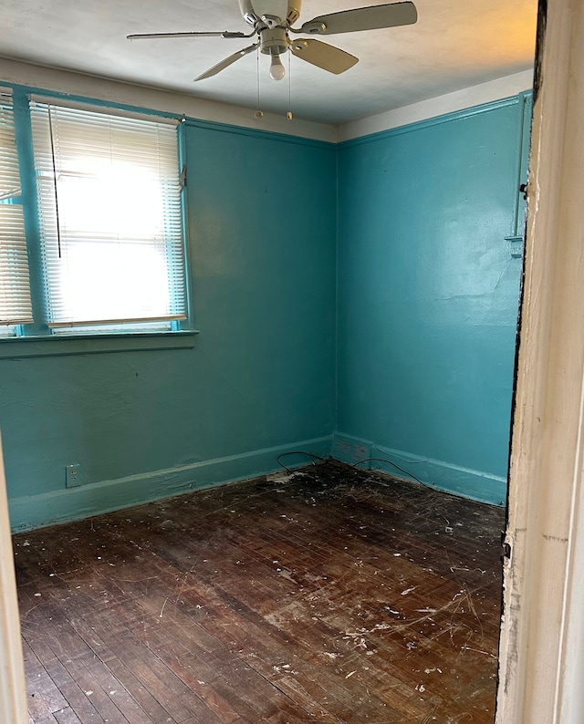 empty room with a ceiling fan and hardwood / wood-style flooring