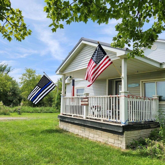 18664 Bradstreet Rd, Hudson, MI 49247 - bungalow-style home with covered porch and a front lawn