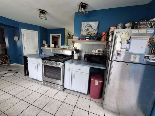 18664 Bradstreet Rd, Hudson, MI 49247 - kitchen with light tile patterned flooring, white cabinets, dark countertops, and stainless steel appliances