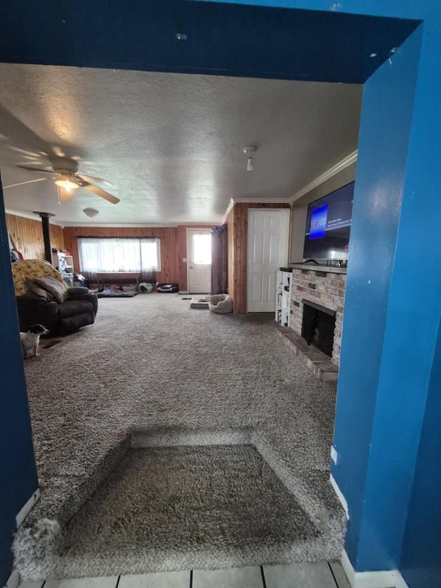 18664 Bradstreet Rd, Hudson, MI 49247 - carpeted living room featuring a textured ceiling, ceiling fan, and a fireplace