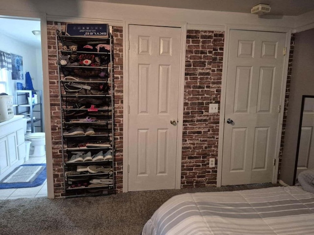 18664 Bradstreet Rd, Hudson, MI 49247 - bedroom featuring connected bathroom and brick wall