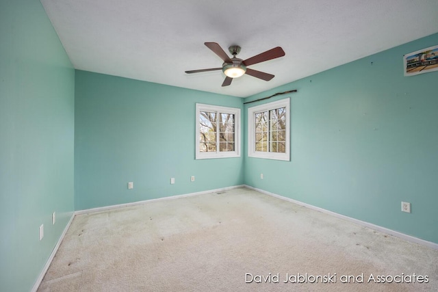 unfurnished room featuring a ceiling fan, baseboards, and carpet